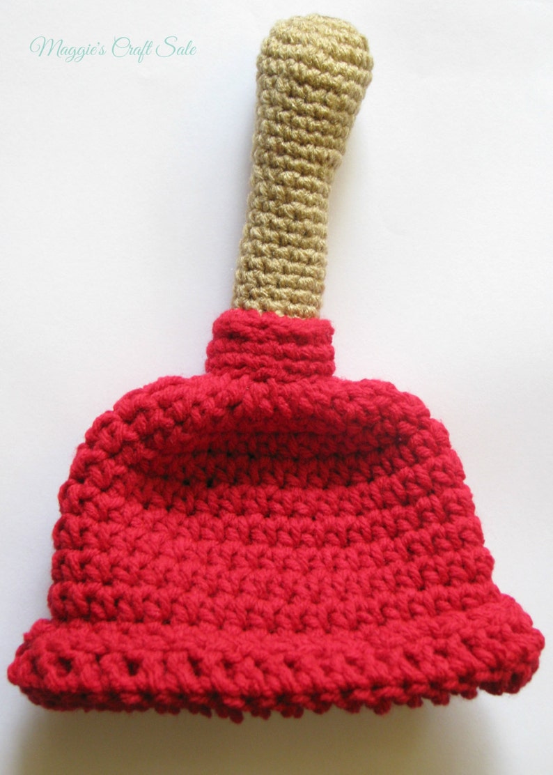 Puede incluir: Un juguete de &eacute;mbolo de crochet con un cuerpo rojo y un mango de color canela.