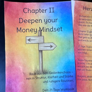 Könnte beinhalten: Eine Arbeitsbuchseite mit regenbogenfarbenem Aquarellhintergrund, dem Text Chapter II Deepen your Money Mindset, einer Illustration eines hölzernen Wegweisers mit Pfeilen sowie dem Text Raus aus dem Gedankenchaos – rein in Struktur.