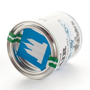 Pu&ograve; includere: Una lattina argentata con un adesivo blu e bianco che presenta la silhouette di un edificio. La lattina ha un'etichetta a strisce verde e bianca con il testo "Salt Lake City" e "Bonner".