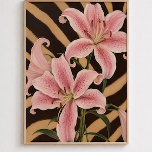 May include: A rectangular wall art print in a light wood frame featuring two large, blooming pink lily flowers with dark speckles. The lilies have prominent stamens and green stems, set against a background of wavy, alternating brown and tan stripes.