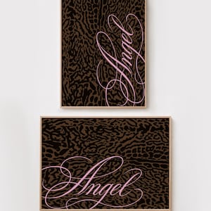 May include: Two framed wall art prints featuring a dark brown and black leopard print pattern. Each print displays the word Angel written in a light pink, cursive, calligraphic script font. One print is oriented vertically and one is horizontal.