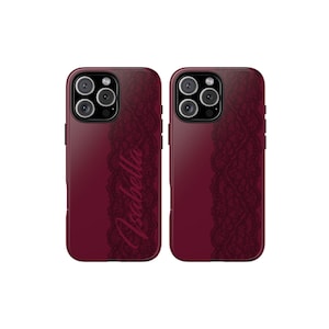 May include: Two burgundy phone cases with a black lace design on the right side. The word "Isabella" is written in cursive on one of the cases. The cases have a glossy finish and a camera cutout.
