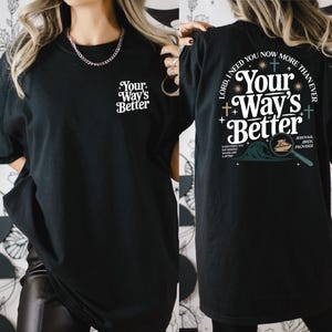 a woman wearing a black t-shirt with a design on the back.