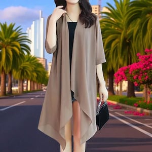 May include: A long, flowing, taupe-coloured cardigan with three-quarter sleeves. The cardigan has an open front and a draped design. The model is holding a small black handbag. The background features palm trees and a city skyline.