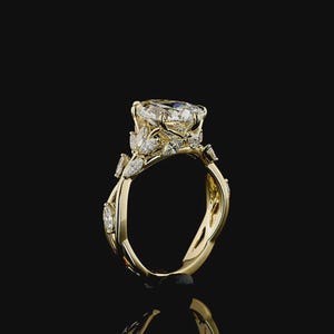 Puede incluir: Un anillo de compromiso de oro con un diamante grande y claro de talla ovalada como pieza central. El anillo presenta diamantes m&aacute;s peque&ntilde;os y detalles en forma de hojas a lo largo de la banda. El anillo est&aacute; sobre un fondo negro.