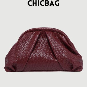 Può includere: Pochette bordeaux con una trama intrecciata. La borsa ha una forma arrotondata con un design a pieghe sul davanti. La parola "CHICBAG" è stampata in nero in alto.
