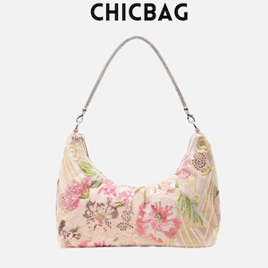 May include: A cream-coloured handbag with a floral design, featuring pink and green embroidered flowers and sequins. The bag has a silver chain strap and the word CHICBAG in black letters at the top.