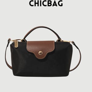 Könnte beinhalten: Schwarze Handtasche mit braunem Überschlag und Griff. Die Tasche hat einen goldenen Reißverschluss und einen abnehmbaren Schultergurt. Das Wort "CHICBAG" ist oben im Bild aufgedruckt.