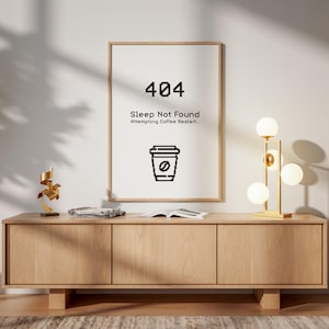 May include: A framed print with the text "404 Sleep Not Found Attempting Coffee Restart..." and a coffee cup icon. The print hangs above a light wood cabinet with a gold lamp and a decorative sculpture. A modern interior design.