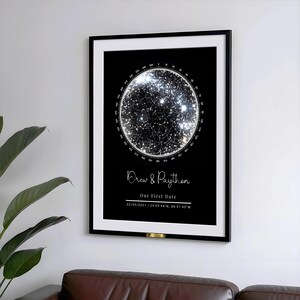 May include: A framed black and white star map print. The print features a circular star chart with a bright, glowing center. Below the chart, the text reads "Drew & Paython" and "Our First Date" with a date and coordinates.