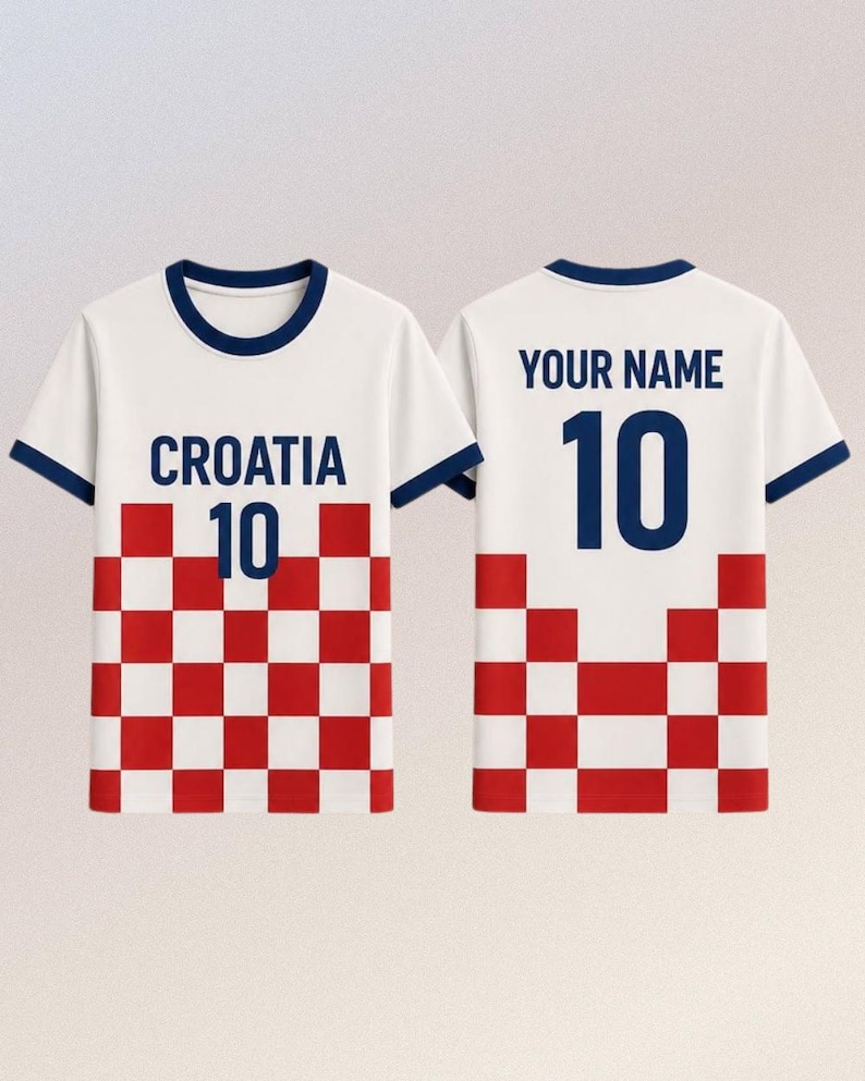 Puede incluir: Camiseta blanca con ribetes azul marino, con la palabra "CROACIA" y el n&uacute;mero "10" en azul marino. La parte inferior tiene un patr&oacute;n de cuadros rojos y blancos. La parte trasera muestra "YOUR NAME" encima del n&uacute;mero "10".