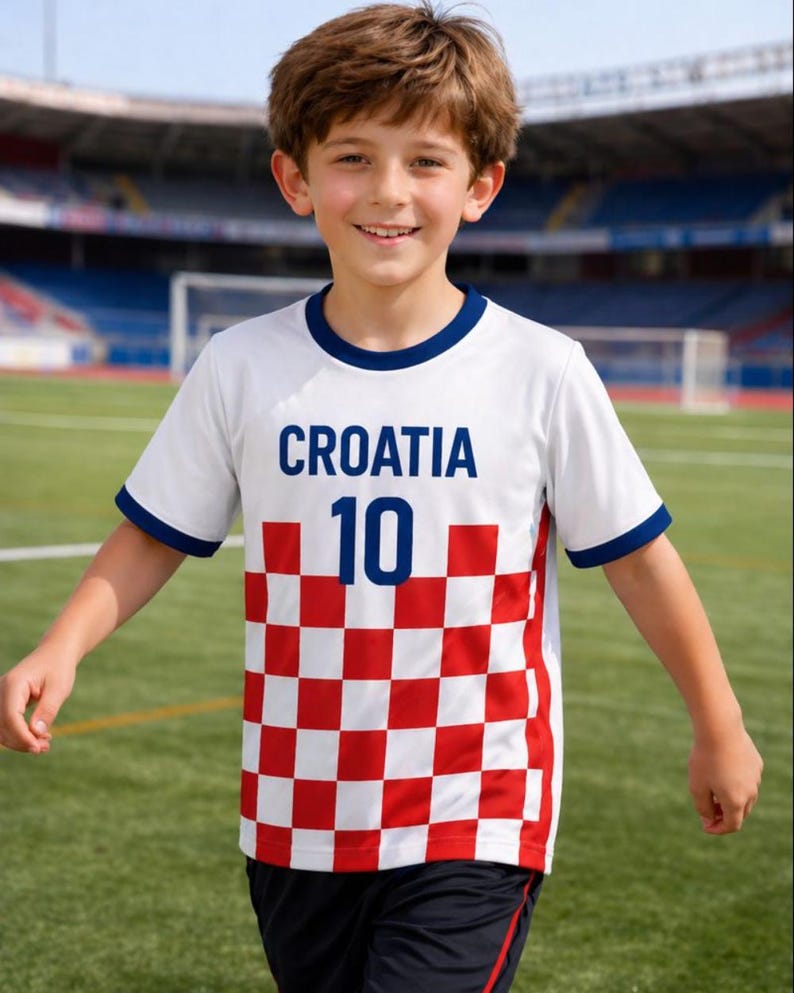Puede incluir: Una camiseta de f&uacute;tbol de Croacia blanca con un dise&ntilde;o a cuadros rojos y blancos en la parte inferior. El n&uacute;mero 10 es azul. La palabra "CROACIA" est&aacute; impresa en azul en el pecho. Ribete azul en el cuello y las mangas.
