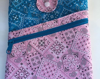 May include: A rectangular fabric pouch featuring a blue and white bandana print on the upper section and a pink and white bandana print on the lower section. It includes a diagonal zippered pocket, a top flap with a snap closure, and blue trim.