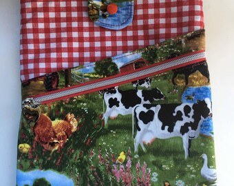 May include: A fabric pouch featuring a red and white gingham top section and a farm-themed lower section with a zipper closure. The lower fabric displays cows, a chicken, a red truck, and a pond. A tab with a snap button secures the top.