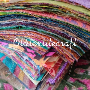 May include: A large stack of square fabric scraps in a variety of colours and patterns, including floral, geometric, and abstract designs. The edges of the fabric pieces are frayed and layered. The text Oldtextilecraft is printed in white across the centre.