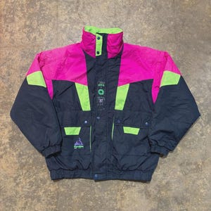 May include: A vintage black and pink ski jacket with neon green accents. The jacket features a high collar, multiple pockets, and the text "Penfield". The jacket is a retro style.