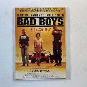 May include: A movie poster for "Bad Boys" featuring Martin Lawrence and Will Smith. The poster has a yellow background with the title in large, bold letters. The actors are in the center, with a car in the background.