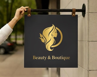 Peut inclure: Panneau carré noir avec un logo doré représentant le profil d'une femme aux cheveux flottants, entouré d'un cercle doré. Les mots "Beauty & Boutique" sont en lettres dorées. Le panneau est suspendu par des lanières de cuir marron.