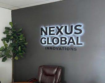 May include: A dark gray wall with the illuminated text "NEXUS GLOBAL INNOVATIONS" in white. A brown leather chair and a round wooden table are in the foreground. A green plant is on the left side of the image.