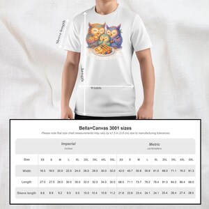 Puede incluir: Camiseta blanca con una ilustraci&oacute;n de acuarela de tres b&uacute;hos y gofres. Los b&uacute;hos son de color naranja, azul y amarillo. El texto "The Eating Way" est&aacute; debajo. El ancho de la camiseta var&iacute;a de 42,0 cm a 81,3 cm.