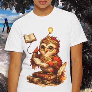 May include: White t-shirt featuring a cartoon owl wearing glasses and a crown, reading a book. The owl is perched on a stack of books with a quill and inkwell. A lightbulb hovers above the owl's head, suggesting an idea.