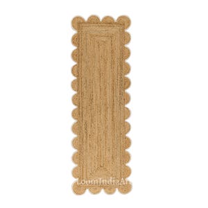 May include: A rectangular jute runner rug with a scalloped edge. The rug is a natural tan color with a woven texture. The scalloped border is a lighter cream color. The text "LoomIndiaArt" is visible at the bottom of the rug.