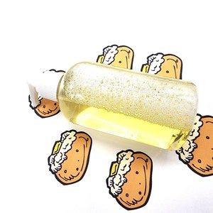 May include: A clear bottle with a white pump dispenser filled with a yellow liquid and bubbles. The bottle is surrounded by five cartoon images of a brown and yellow sandwich with a white filling.