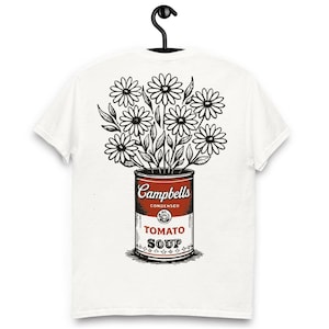 Op de afbeelding: Wit t-shirt met een afbeelding van een Campbell's Tomato Soup-blik met madeliefjes. Het blik is rood en wit met de tekst "Campbells Condensed Tomato Soup". De madeliefjes zijn zwart en wit.