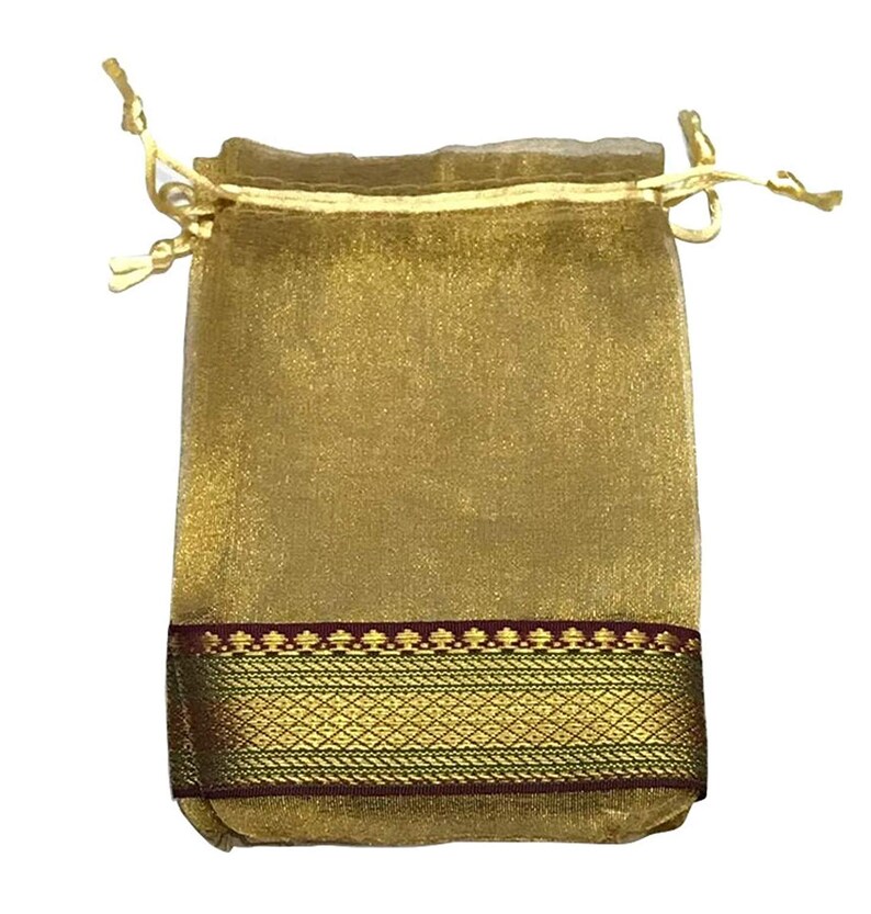 May include: A gold-colored drawstring pouch with a decorative band of gold and maroon. The pouch is made of a sheer, shimmering fabric and is tied with a gold cord.
