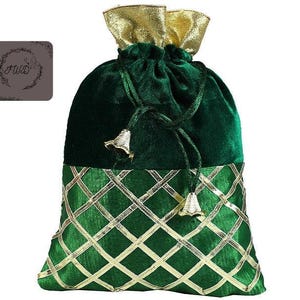 May include: A green velvet drawstring bag with gold accents. The bag features a gold lattice pattern on the lower section and a gold metallic top. The drawstring is tied with gold bell-shaped tassels. The bag has a decorative logo on the upper left.