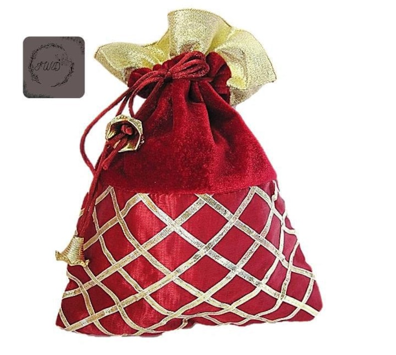 May include: A red velvet drawstring gift bag with gold accents. The bag features a gold diamond pattern on the lower half and a gold ribbon closure. The top is a gold fabric, and the bag has gold tassels.