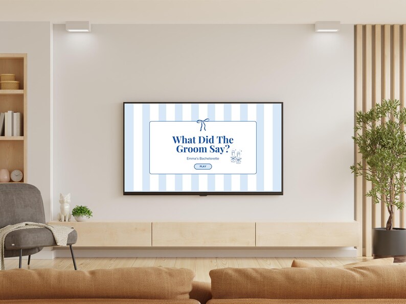 May include: A flat-screen TV displays a game titled "What Did The Groom Say?" against a blue and white striped background. The game is for Emma's Bachelorette party. The TV is mounted on a light wood cabinet in a living room setting.