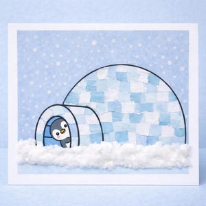 May include: A greeting card featuring a whimsical illustration of a penguin peeking out from an igloo. The igloo is constructed with blue and white paper squares, set against a light blue snowy background. Fluffy white cotton simulates snow.