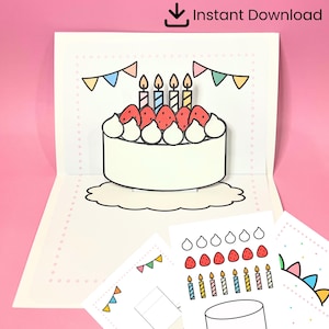 Puede incluir: Una tarjeta de cumpleaños desplegable con una tarta con fresas, velas y nata montada. La tarjeta tiene una base en forma de nube y está decorada con banderines de colores. Las palabras "Instant Download" están en la parte superior.