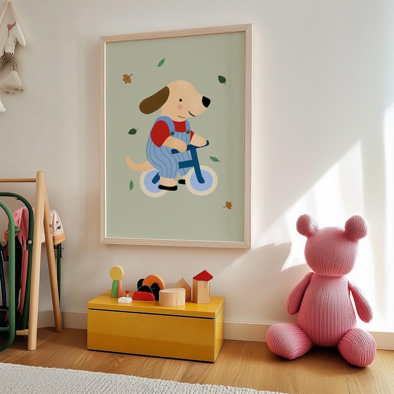 K&ouml;nnte beinhalten: Gerahmter Kunstdruck mit einem Cartoon-Hund auf einem Fahrrad, gekleidet in einem roten Hemd und blauen Latzhosen. Der Hintergrund ist hellgr&uuml;n mit verstreuten Bl&auml;ttern. Eine gelbe Spielzeugkiste und ein rosa Teddyb&auml;r befinden sich im Vordergrund.