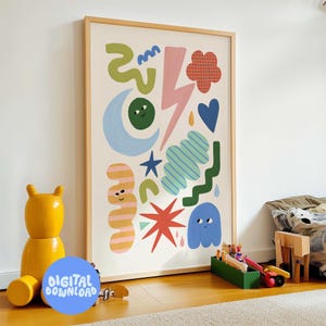 May include: A framed art print with a collection of colourful abstract shapes, including a moon, star, and lightning bolt. The artwork is in a light wood frame and is labelled "DIGITAL DOWNLOAD" in a blue circle. A yellow wooden bear and toys are in the foreground.