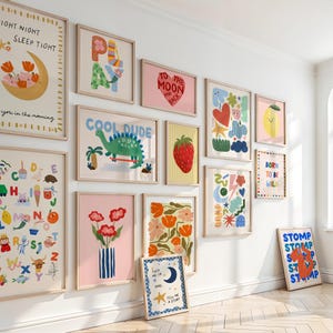 Puede incluir: Una colecci&oacute;n de l&aacute;minas art&iacute;sticas enmarcadas con diversas ilustraciones y texto. Las l&aacute;minas presentan dise&ntilde;os coloridos, incluyendo un dinosaurio, una fresa, flores y frases como "Cool Dude" y "To the Moon and Back". Los marcos son de madera clara.