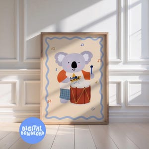 May include: A framed print featuring a cartoon koala playing a red drum. The koala wears an orange shirt with the word "COOL" and blue shorts. Musical notes and a blue border surround the image. A blue circle with "DIGITAL DOWNLOAD" is at the bottom.