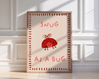 Puede incluir: Un estampado enmarcado con una ilustración de mariquita roja y el texto "SNUG AS A BUG" en rosa. La mariquita tiene un lazo en forma de corazón y una cara sonriente. El marco es de color marrón claro.
