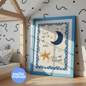 May include: A framed print with a blue border features the text "Tuck me in and... Tell me a story." The artwork includes a navy blue crescent moon, a gold star, and other stars. The background is a light beige with a blue checkered border.