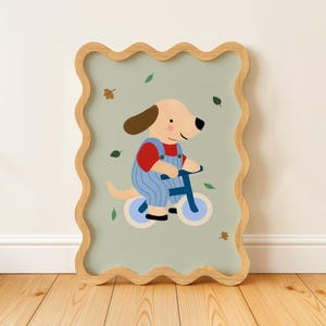 K&ouml;nnte beinhalten: Gerahmte Illustration eines Cartoon-Hundes auf einem blauen Fahrrad. Der Hund tr&auml;gt ein rotes Hemd und eine blaue Latzhose. Der Hintergrund ist hellgr&uuml;n mit verstreuten Bl&auml;ttern. Der Rahmen ist helles Holz.