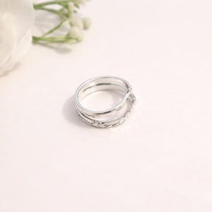 Può includere: Un anello d'argento dal design unico a strati. L'anello presenta una superficie strutturata con dettagli intricati. Questo gioiello è adatto per l'uso quotidiano o per occasioni speciali.