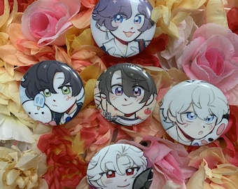 May include: A collection of six round anime-style character buttons with colorful illustrations. The buttons feature various characters with different hair colors and expressions. The buttons are arranged on a bed of colorful artificial flowers.