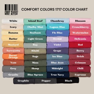 May include: A Comfort Colors 1717 color chart by Gray Seven7 displaying a grid of folded t-shirts in various shades including white, ivory, banana, butter, mustard, terracotta, burnt orange, yam, grey, granite, graphite, island reef, chalky mint, seafoam, light green, bay, khaki, sage, moss, hemp, blue spruce, pepper, chambray, lagoon blue, flo blue, orchid, violet, grape, ice blue, blue jean, midnight, true navy, blossom, crunchberry, watermelon, heliconia, red, berry, brick, crimson, chili, espresso, and black.