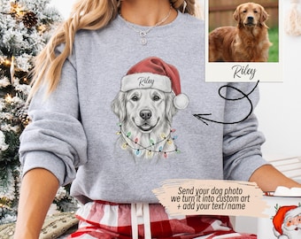 May include: A light gray sweatshirt featuring a custom dog portrait wearing a Santa hat and Christmas lights. The dog's name, "Riley," is on the hat. A photo of a golden retriever named Riley is also shown. Text on the sweatshirt says "Send your dog photo we turn it into custom art + add your text/name."