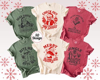 May include: A collection of Christmas-themed t-shirts in various colors, including green, cream, and red. Each shirt features a unique graphic design with humorous text, such as "Dear Santa, I Can Explain" and "Check Out My Balls."