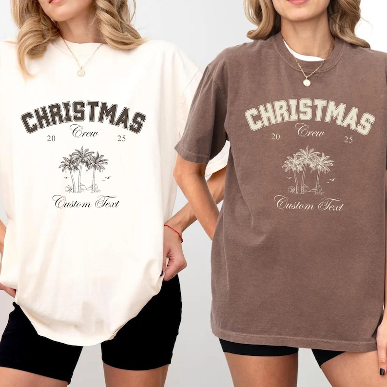 May include: Two short-sleeve t-shirts, one cream and one brown, each featuring the text CHRISTMAS Crew 20 25, a graphic of three palm trees, and the words Custom Text. The shirts have a crew neckline and a relaxed fit design.