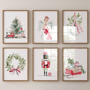 May include: Six framed watercolor prints with Christmas themes. The prints depict a Christmas tree, an angel, a holiday ornament, a wreath, a nutcracker, and a sleigh filled with gifts. The frames are brown, and the artwork features red, green, and pink accents.