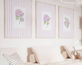 May include: A light-filled living room with a neutral color palette. Three framed floral prints hang above a light pink sofa with matching pillows. A wooden coffee table and white shelving unit complete the space.
