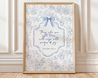 Puede incluir: Impresión enmarcada con un patrón floral azul y blanco. La obra de arte incluye un lazo azul claro y una cita de Salmos 126:6 en un marco decorativo. El texto dice: "Los que sembraron con lágrimas, cosecharán con cánticos de alegría..."